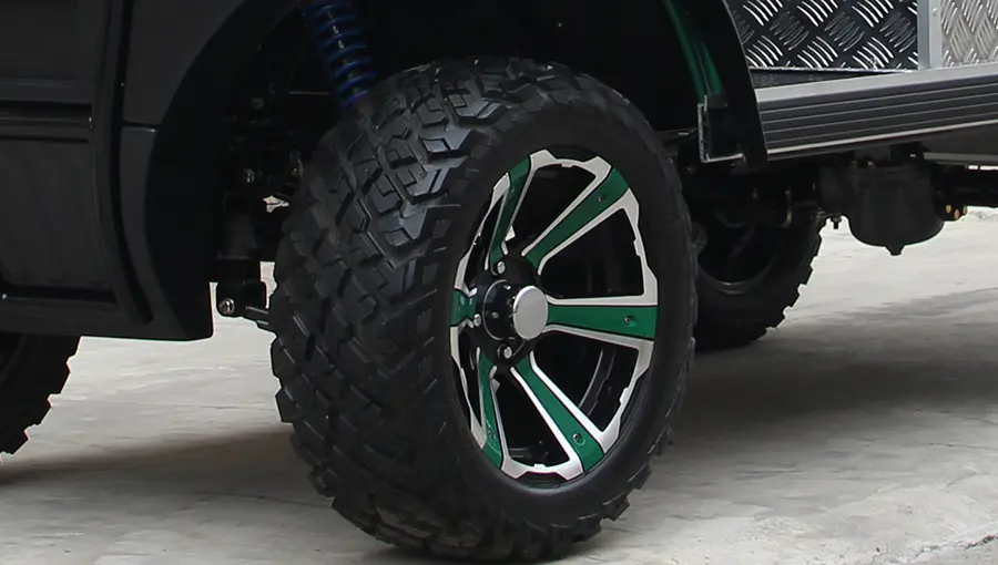 Close-up of Tara medium speed vehicle tire with deep off-road tread pattern, designed for superior traction on dirt and grass